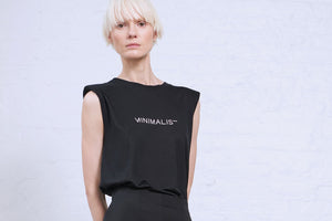 Model wearing black sleeveless tee with shoulder pads