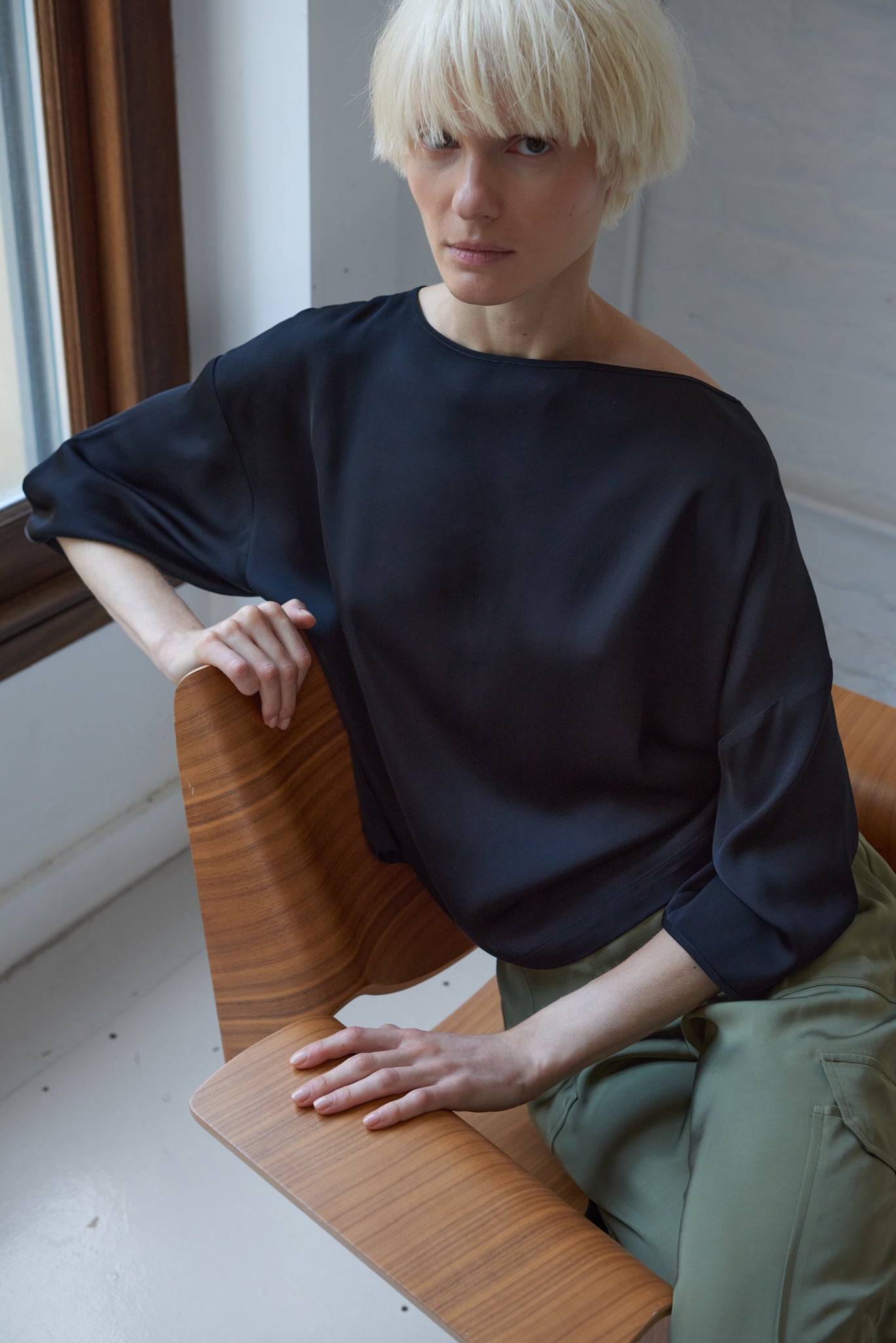 woman wearing satin boatneck top made from sustainable viscose in black 