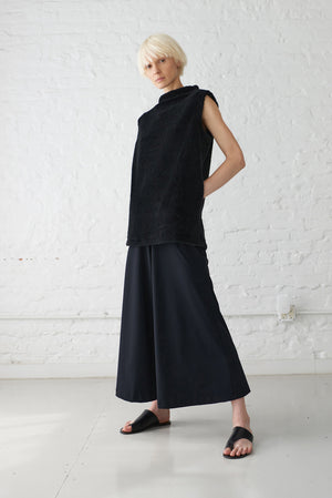 woman wearing pullover vest made with organic cotton yarn in black and wide leg palazzo pants