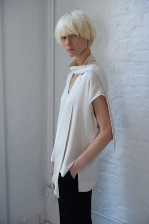 woman model wearing tie neck blouse made with a luminous polished viscose satin in ivory