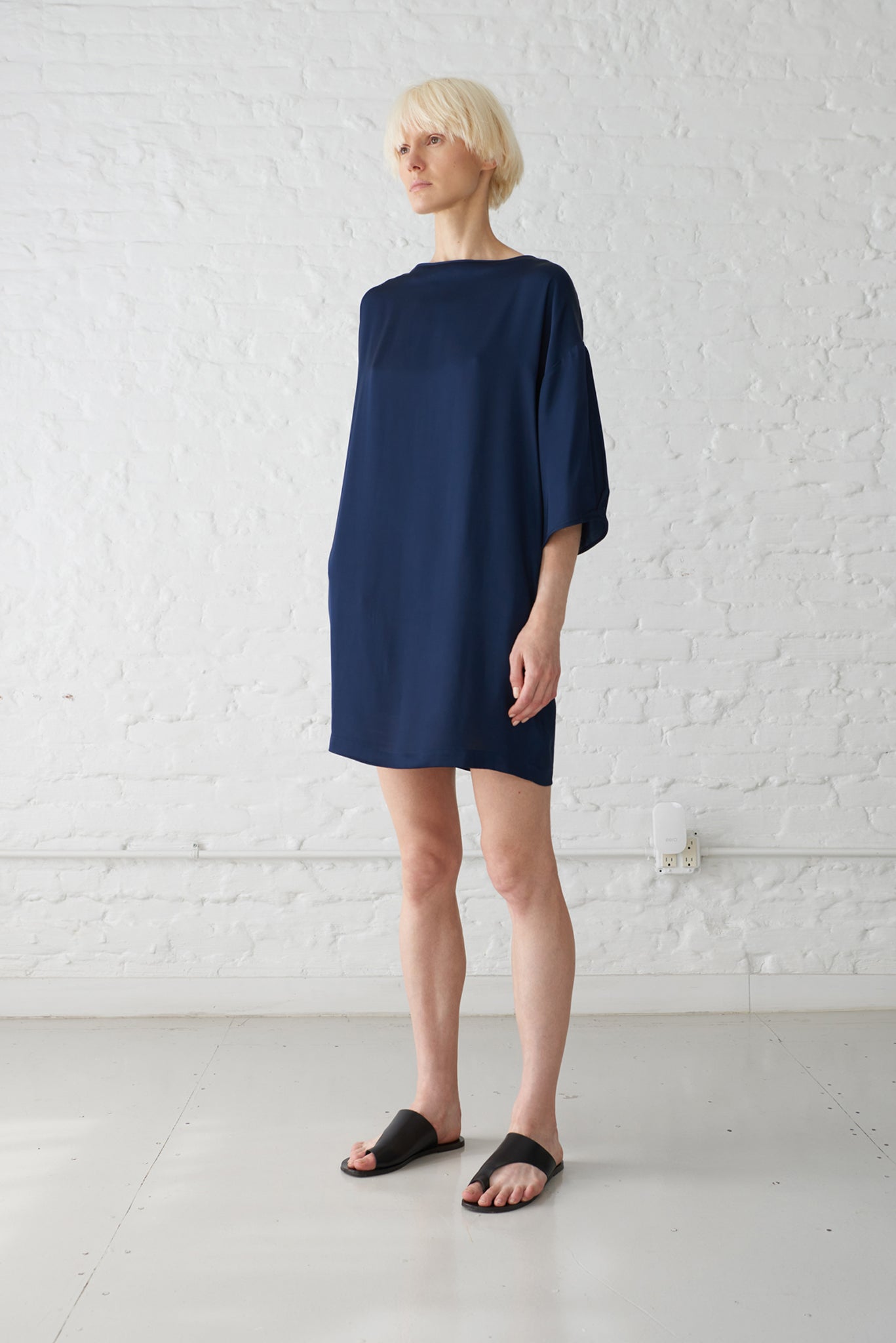 woman wearing kimono sleeve dress made from sustainable viscose fabric in navy blue