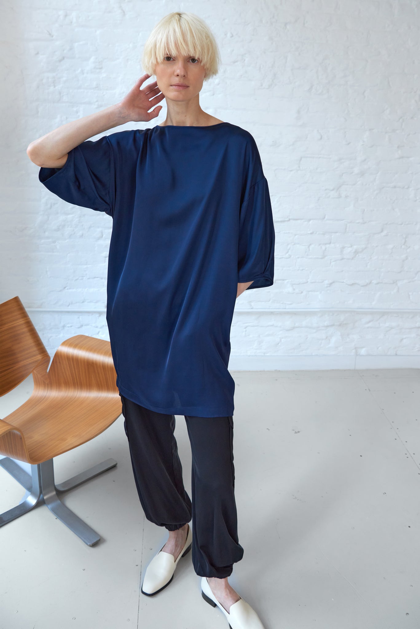 woman wearing kimono sleeve dress made from sustainable viscose fabric in navy blue and jogger pants front view
